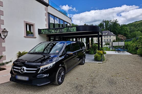 Van Mercedes noir devant l’entrée d’un hôtel